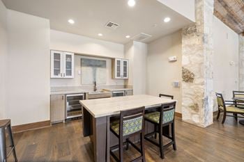 A kitchen with a large island with four chairs in front of it